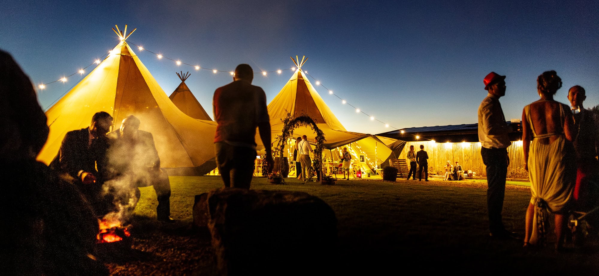 wedding guests talking outside tipi